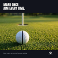 A golf ball marked with the Halo lined up to the hole on a putting green, flagstick behind it